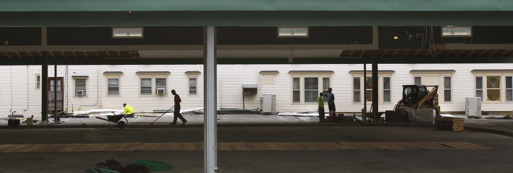 Workers place paving stones and sweep the edge of the Waterhouse Center in Kennebunk. The center will house an ice skating rink in the winter and other events throughout the year.