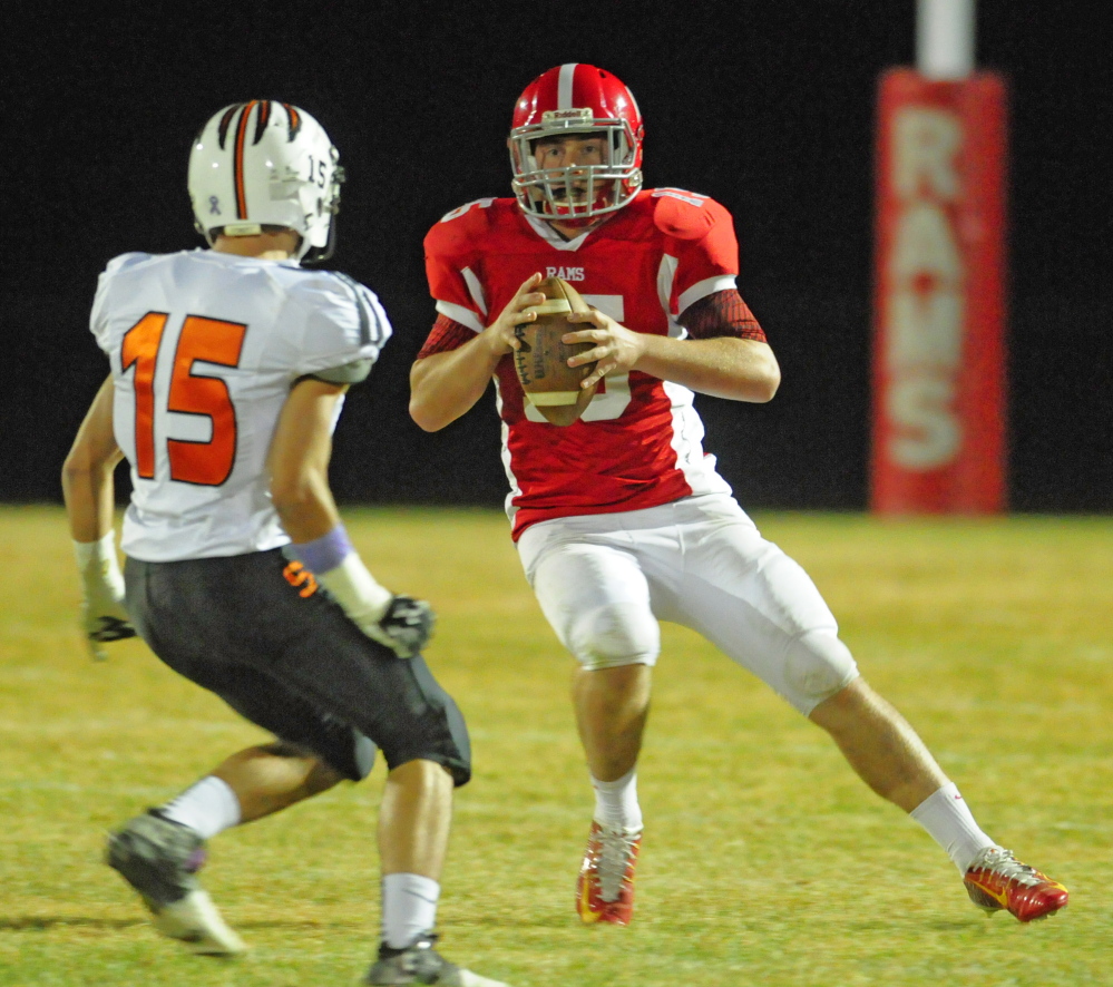 Staff file photo by Joe Phelan 
 Skowhegan Kam Doucette, left, chases Cony quarterback Mitchell Caron during a Pine Tree Conference Class B game Friday night. The Rams scored an important victory to keep pace with Brunswick and Lawrence.