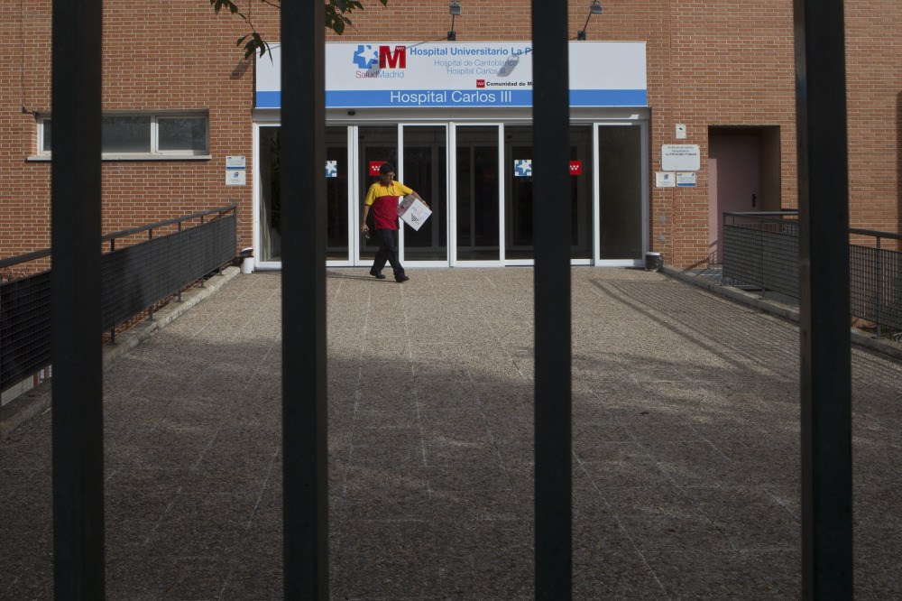 A workers makes a delivery at the entrance of the Carlos III  hospital in Madrid, Spain, Tuesday where a Spanish nurse who is believed to have contracted the ebola virus from a 69-year-old Spanish priest is being treated after testing positive for the virus.