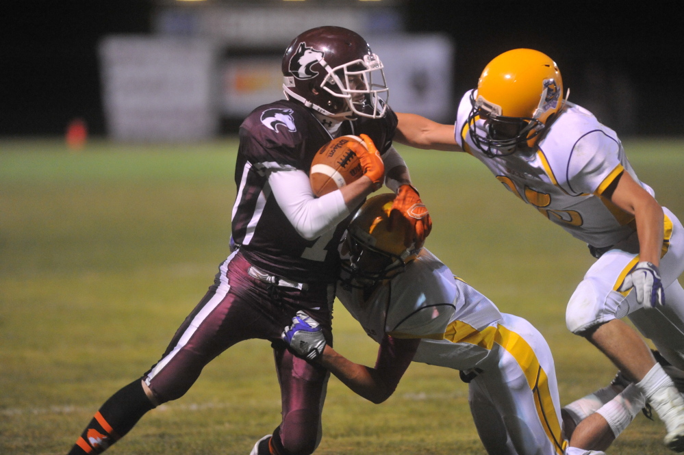 Maine Central Institute’s Austin Tolman, left, tries to break free from a pair of Bucksport defenders during a Little Ten Conference game Sept. 19.