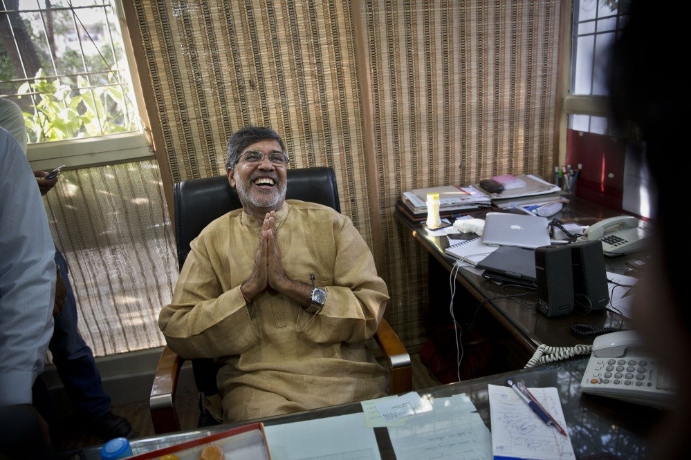 Indian children’s rights activist Kailash Satyarthi laughs as he addresses the media at his office in New Delhi, India, on Friday, Oct. 10 after learning he and Malala Yousafzai of Pakistan jointly won the Nobel Peace Prize.