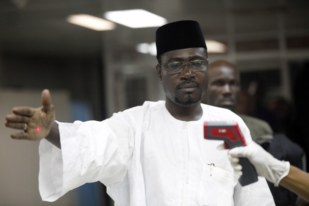 In this Aug. 2014 file photo, a Nigerian port health official uses a thermometer on a passenger at the arrivals hall of Murtala Muhammed International Airport in Lagos, Nigeria. The Obama administration’s plans to screen certain airline passengers for exposure to Ebola are based on the Constitution and long-established legal authority that would almost certainly stand up in court if challenged, public health experts say. Airline passengers arriving from three West African countries will face temperature checks using no-touch thermometers and other screening measures at five U.S. airports, starting with New York’s Kennedy International on Saturday.