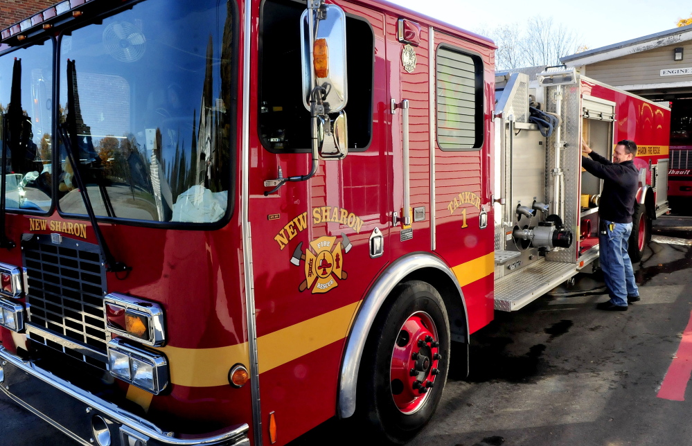 New Sharon firefighter Jason Lunt and others work on a tanker at the department on Sunday. New Sharon and other Franklin County departments will meet Oct. 29 and discuss regionalizing to save money and resources.