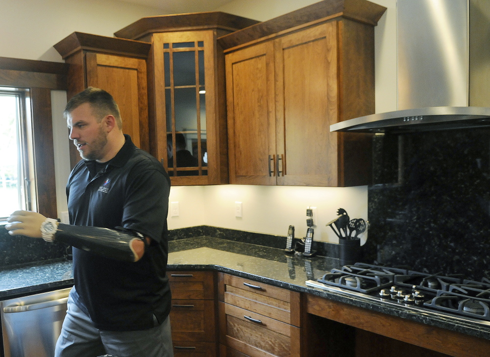 Travis Mills describes the adaptive kitchen in his family’s new Manchester home on Wednesday.