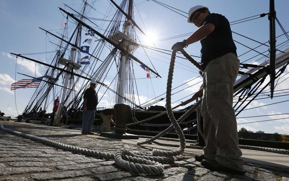 A dock crew secures The USS Constitution after the ship’s final tour of Boston Harbor, Friday, in Boston, before entering dry dock for a three-year restoration project.