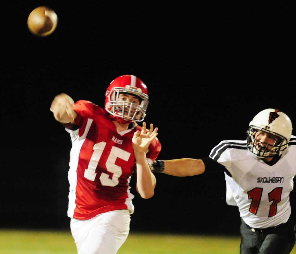 Staff file photo by Joe Phelan 
 Cony quarterback Mitchell Caron gets a throw off as Skowhegan defensive end Ryan Prentiss grabs him during a Pine Tree Conference Class B game on Oct. 3.