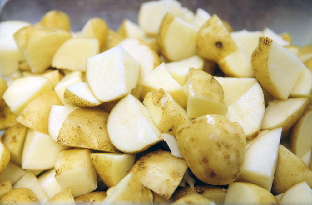 Joe Phelan/Staff Photographer
The potatoes grown by Kennebec County jail inmates are cut up to be used in mashed potatoes.