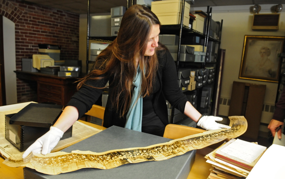 Special collections librarian Dawn Thistle unrolls a panoramic photographic during an interview last week at the Gardiner Public Library.