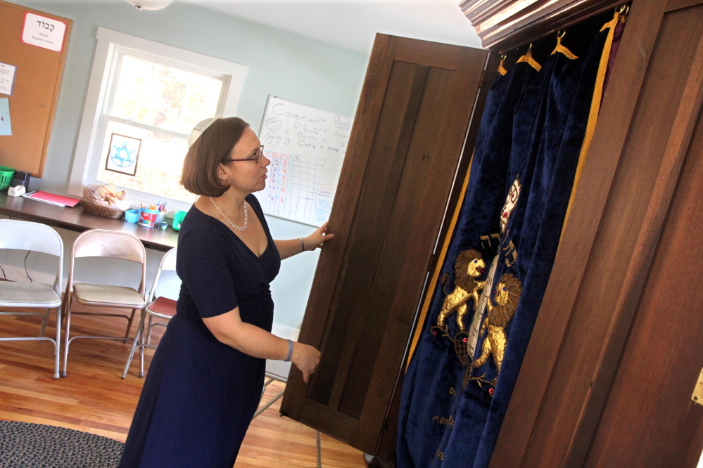 Temple Beth El Rabbi Erica Asch opens an ark that once belonged to the Gardiner congregation inside the Nancy and Charlie Shuman Center for Jewish Learning after the building’s dedication in Augusta on Sunday. Part of the dedication involved the moving of the ark from the sanctuary at Temple Beth El to the learning center.