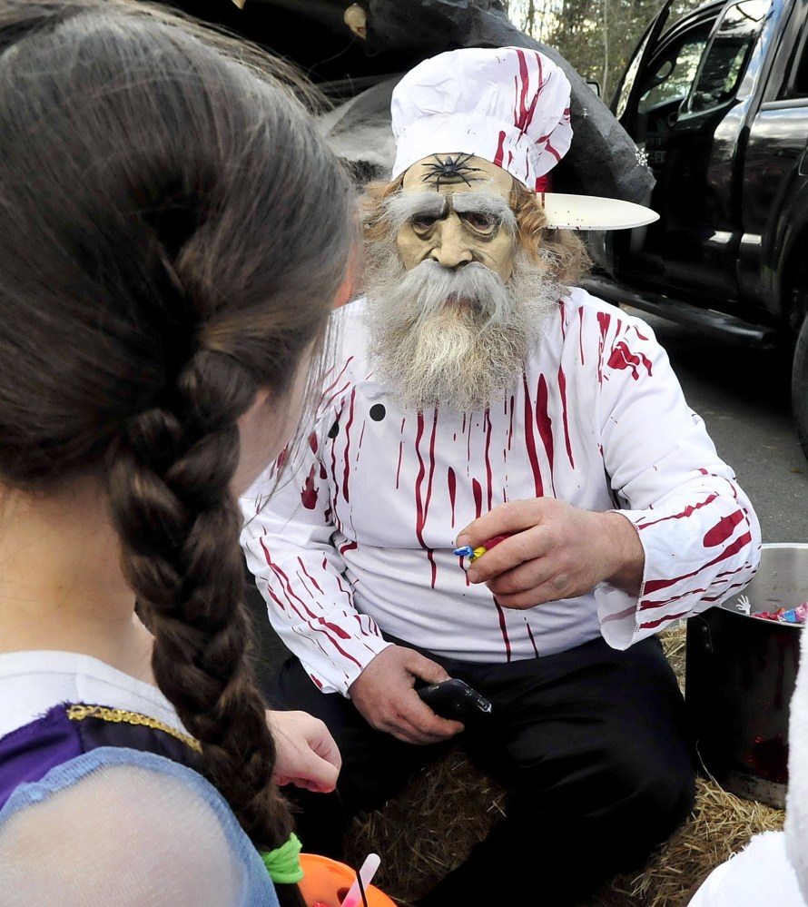 Sporting a bloody knife through his head, Toby Wagg hands out candy to some of the more than 200 Halloween costumed kids who turned out for the second annual Trunk-or-Treat event at Canaan Elementary School on Sunday. Thirty decorated vehicles and owners handed out candy or offered tricks to kids as an alternative to door-to-door trick or treating, according to Parent Teacher Fellowship member Crystal Reed. “This is a safer alternative,” Reed said.