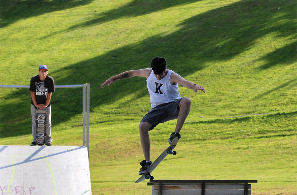 Billy Peaslee, left, watches as his friend Rick Morrow performs a trick at the skate park off Sherwin Street in Waterville this August.