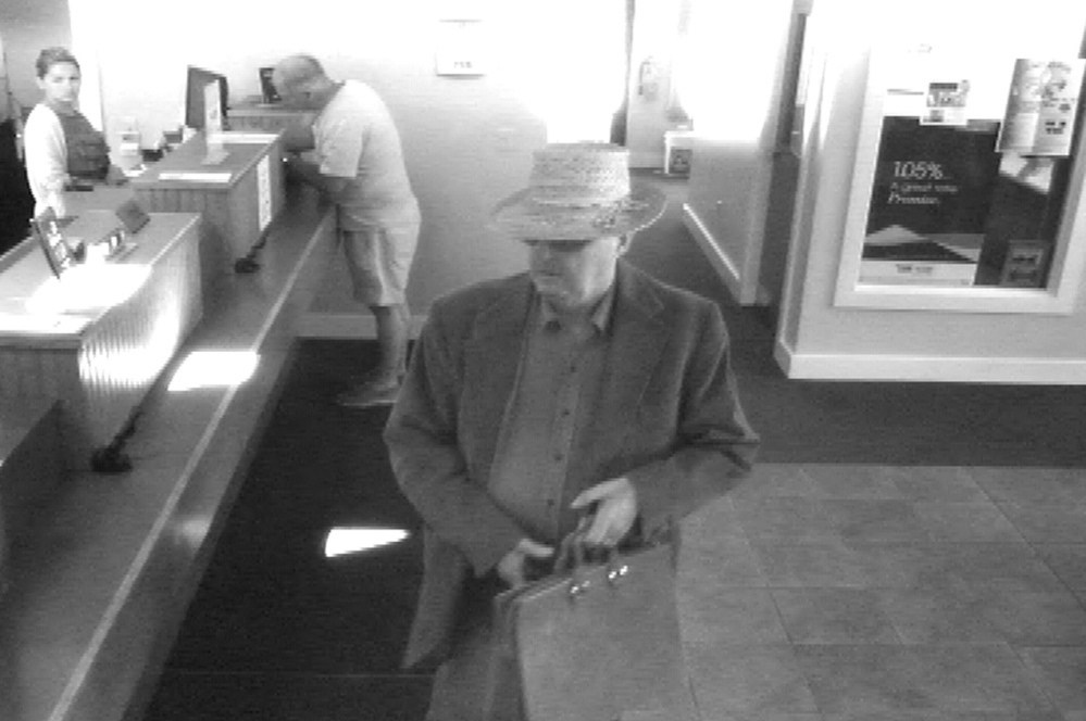 This surveillance photo shows the robbery in progress June 23 at the Bank of Maine Hallowell branch. John Cecil Slater, 66, pleaded guilty Tuesday to the robbery.