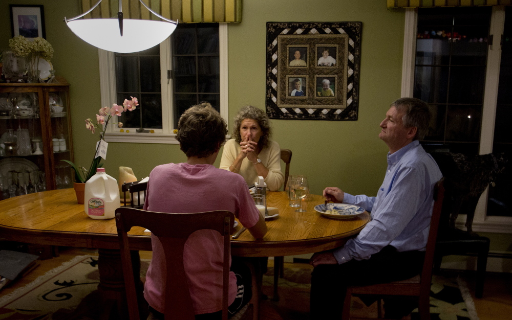 Sheri Clark Nadell, center, talks with her son Aaron, and husband, Paul, while they have dinner in their Brunswick home Thursday. The Nadells put their first two sons through college and are preparing to do the same for Aaron, but not without amassing debt of their own because of the rising cost of higher education.