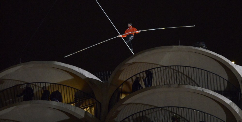 Daredevil Nik Wallenda begins his tightrope walk uphill at a 15-degree angle from the Marina City west tower across the Chicago River to the top of the Leo Burnett Building in Chicago, Sunday