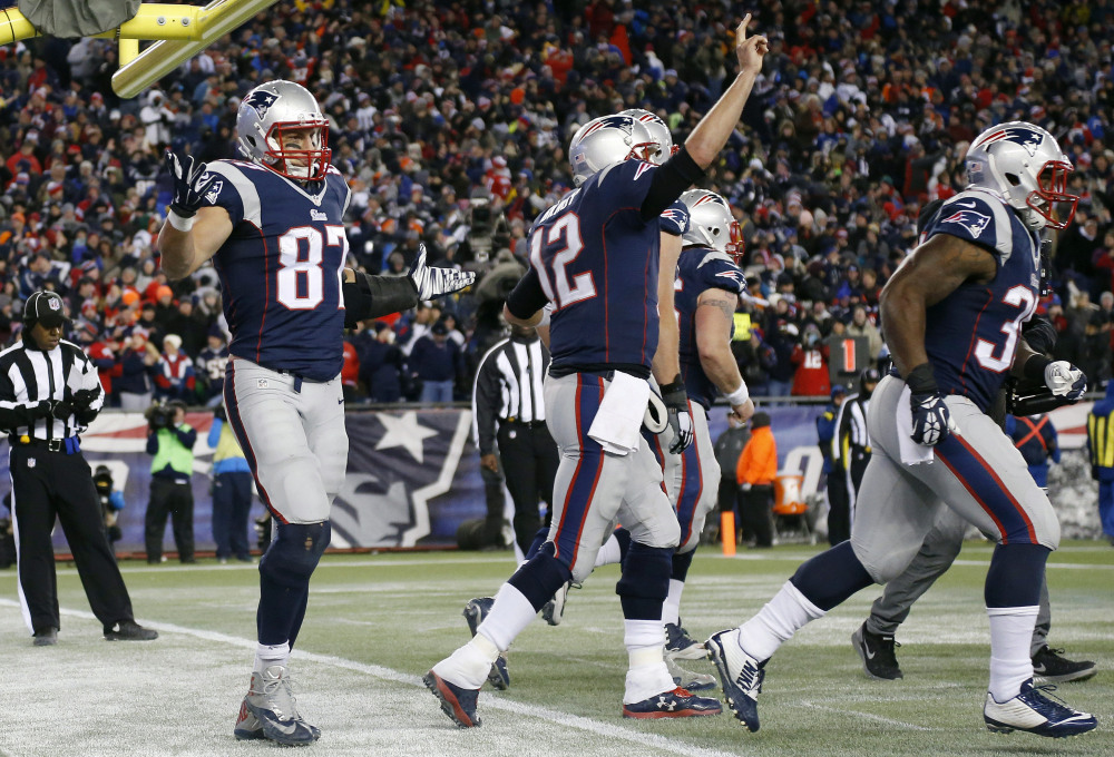 New England Patriots tight end Rob Gronkowski, left, celebrates after catching a touchdown pass from quarterback Tom Brady, celebrating at center, in the second half Sunday against the Denver Broncos in Foxborough, Mass. The Patriots won 43-21.
