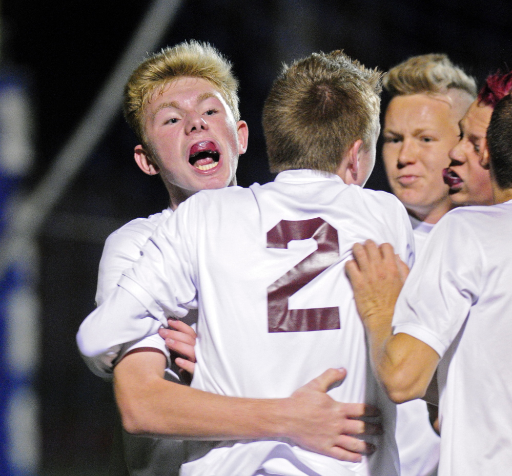 Richmond’s Brendan Emmons is hugged by teammates after scoring the winning goal to put Bobcats up 1-0 over Buckfield during the Western Maine Class D boys soccer final on Wednesday.