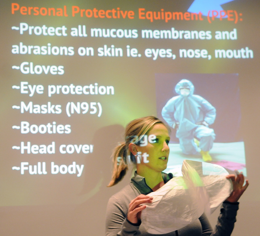 Kerry Gilmore, director of sales for 24-Trauma/Restore, teaches housing authority employees and landlords Wednesday how to protect themselves with booties while cleaning up a biohazard in an apartment during a course at City Center in Augusta.