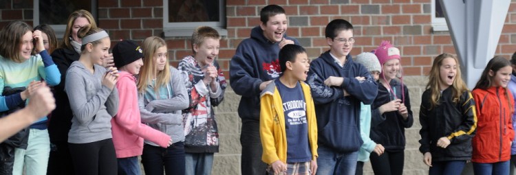 Maranacook Community Middle School students watch pumpkins hit the pavement at the school in Readfield on Monday after being dropped from a Central Maine Power bucket truck. The students were learning about Newton’s laws of physics for a class.