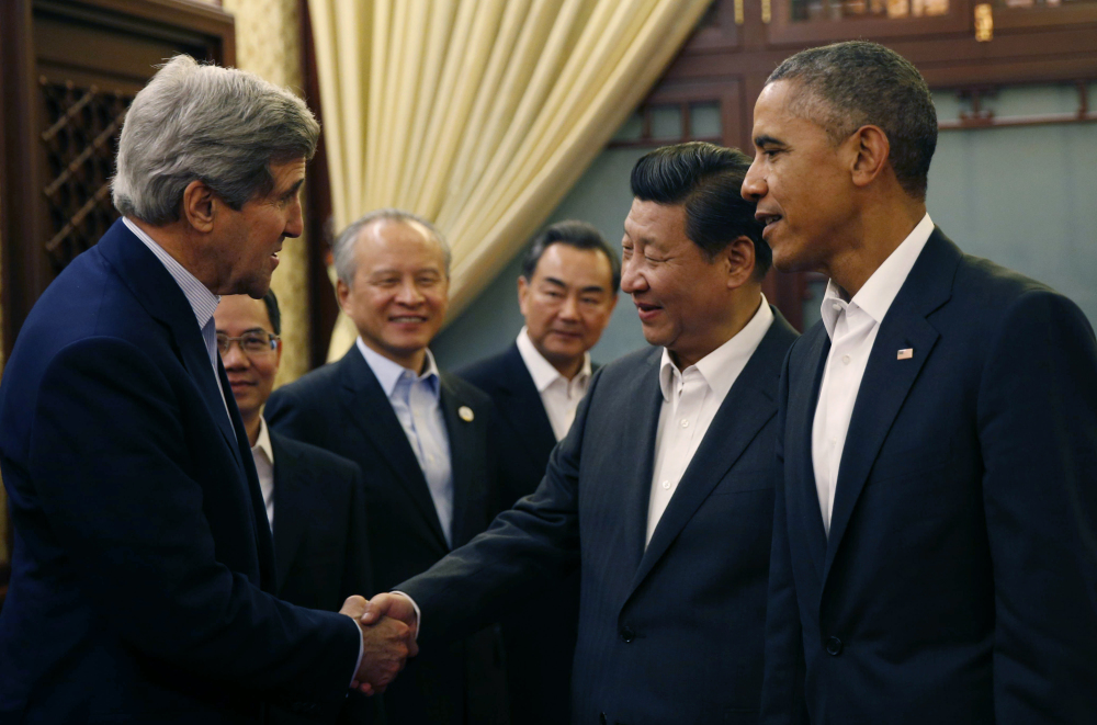 U.S. President Barack Obama, right, looks on as China’s President Xi Jinping, second right, shakes hands with U.S. Secretary of State John Kerry, left, at the start of a meeting after participating in the Asia Pacific Economic Cooperation (APEC) summit at the Zhongnanhai leadership compound in Beijing Tuesday. Obama has also met with Russian President Vladimir Putin while at the summit.
