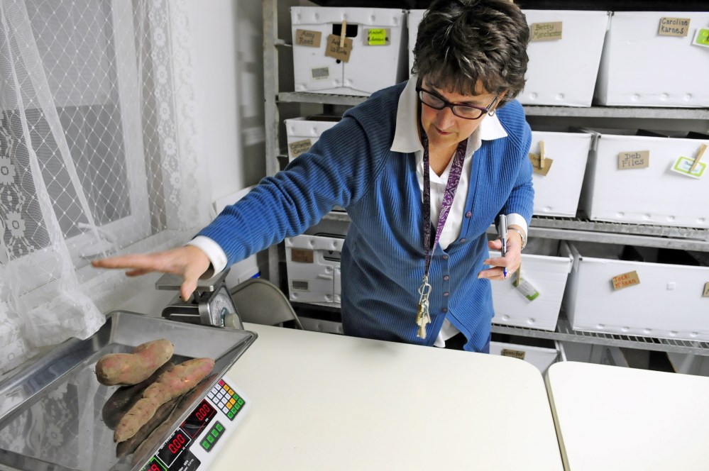 Betty Morrell, online marketplace manager for the Kennebec Local Food Initiative Online Buying Club, weighs sweet potatoes last week at Faith Christian Church in Gardiner. On Saturday, the group plans to announce a storefront location in downtown Gardiner.