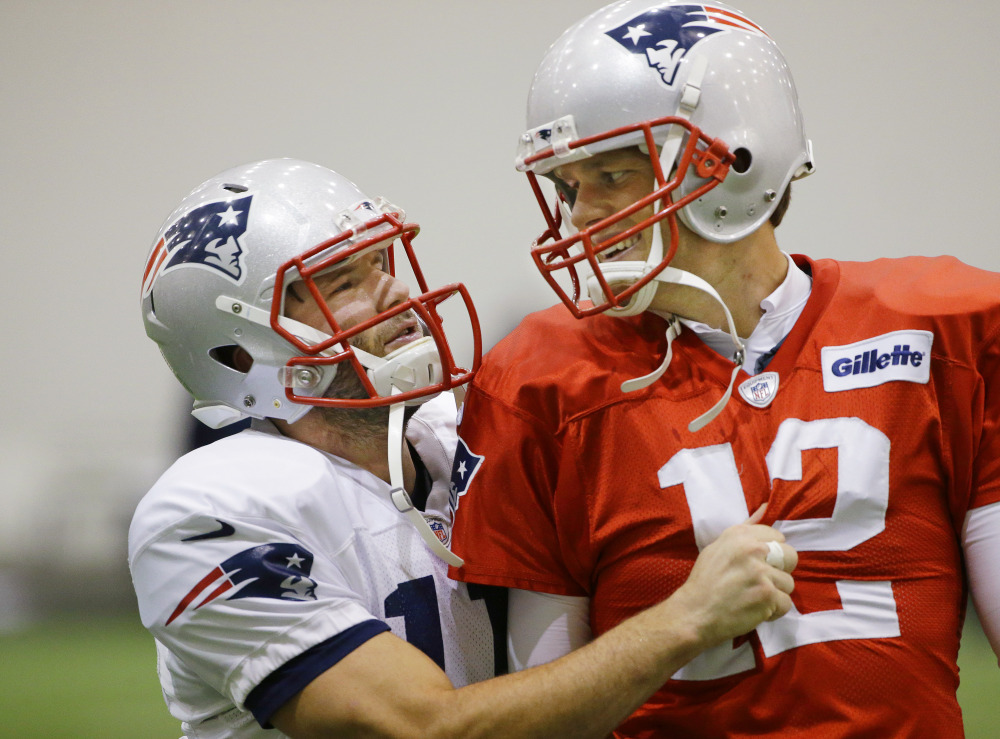 New England Patriots wide receiver Julian Edelman (11) grabs the jersey of quarterback Tom Brady (12) during a stretching session before practice begins at the team’s facility Wednesday in Foxborough, Mass. The Patriots will play the Indianapolis Colts Sunday in Indianapolis.