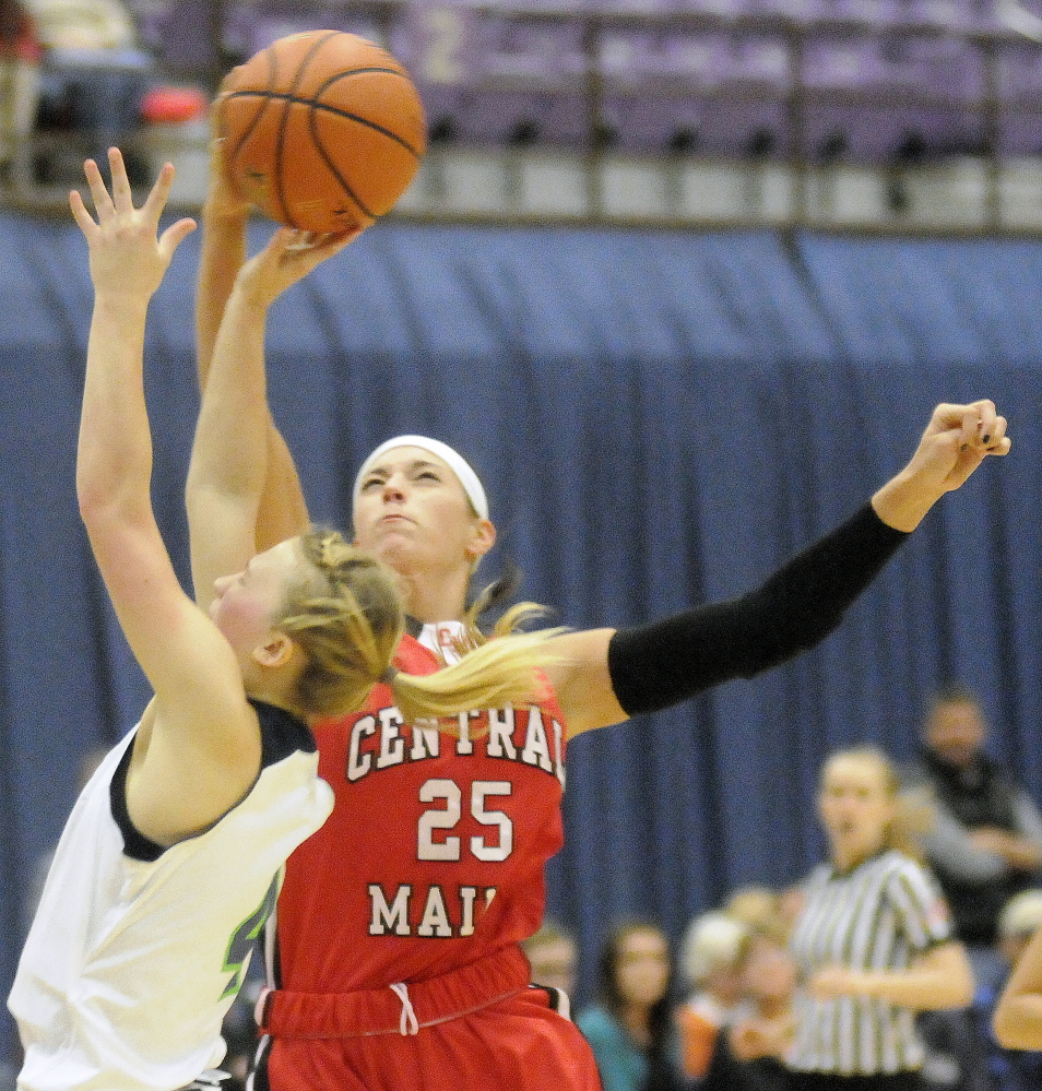 Staff photo by Andy Molloy 
 University of Maine at Augusta forward Kylie Kemp has her shot altered by Central Maine Community College's Laura Soohey during during a game Wednesday at the Augusta Civic Center.