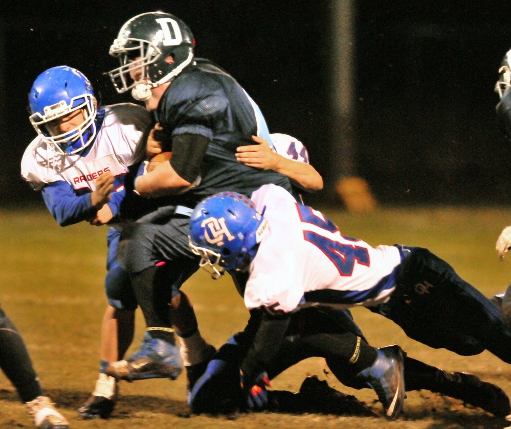 Oak Hill defenders Levi Buteau, left, Kyle Flaherty, in background, and Kyle Tervo bring down Dirigo fullback Tyler Frost during a Western D semifinal last Friday.
