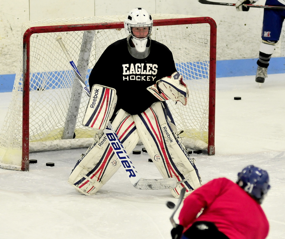 Staff photo by David Leaming 
 Messalonskee goalie Elijah Tuell blocks some pucks from teammates during practice Monday at Sukee Arena in Winslow.