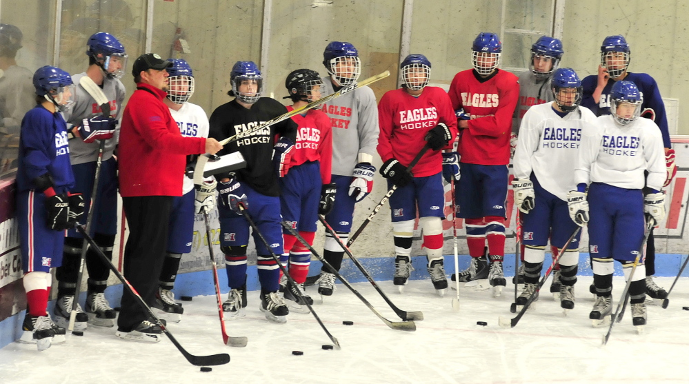 New Messalonskee hockey coach Joseph Hague, left, leads the team during practice Monday at Sukee Arena in Winslow. Teams around the area opened winter sports practices Monday.