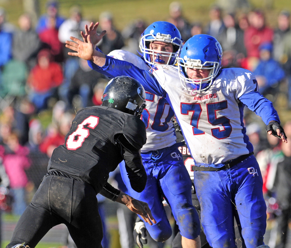 Lisbon quarterback Tyler Halls, left, just gets the pass off as Oak Hill defensive linemen Mike Pease, center, and Garrett Gile converge on the play during the Western D Campbell Conference title game last Saturday.