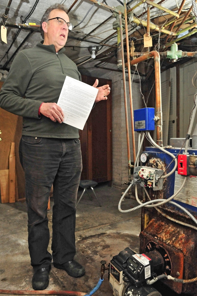 John Shaw talks about the contract he had with David Ireland for furnace work on Tuesday in the basement of a rental home he owns in Gardiner.