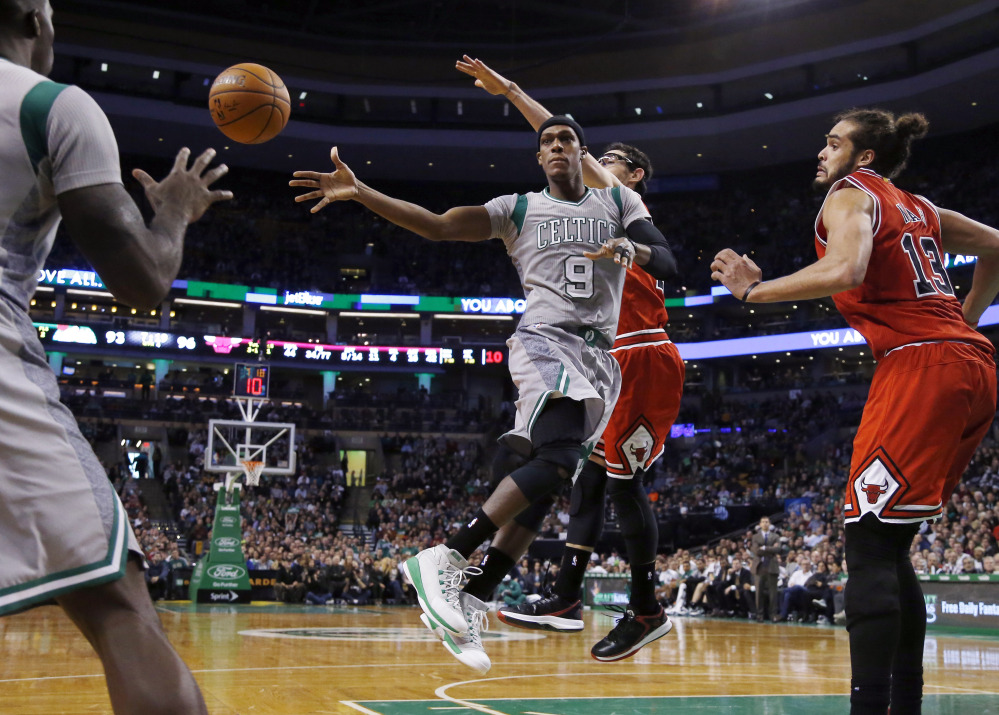 Boston Celtics guard Rajon Rondo (9) dishes to a teammate as he drives against Chicago Bulls guard Kirk Hinrich and center Joakim Noah (13) in the second half Friday in Boston. The Bulls won 109-102.