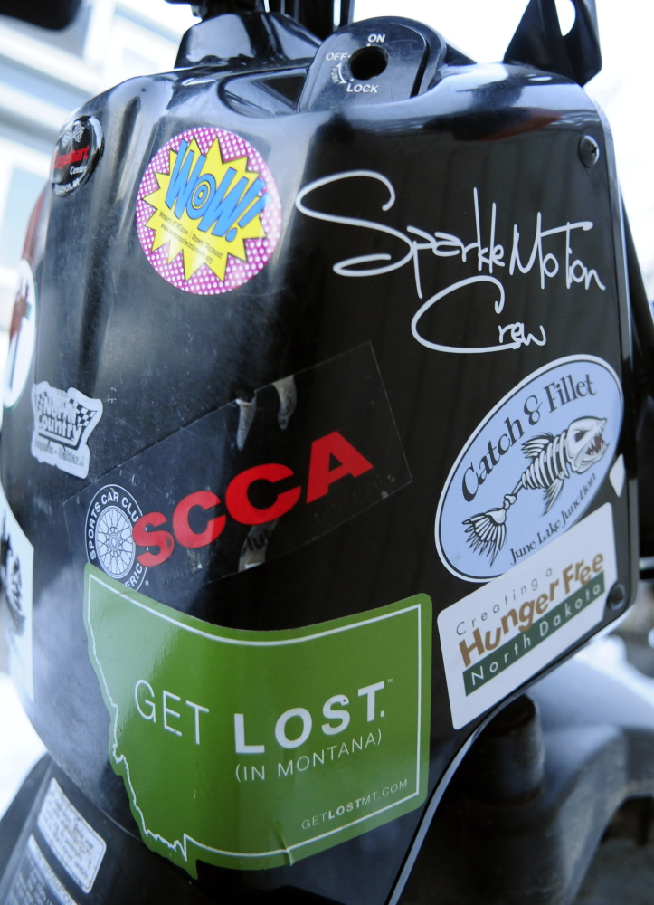 Stickers collected during a cross-country trip cover Dan Emery’s Honda scooter Thursday in Augusta.
