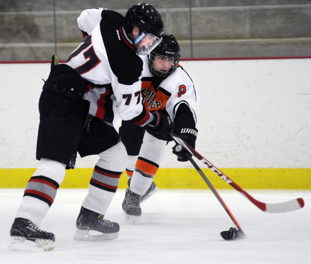 Gardiner Area High School’s Casey Vandenbauch, right, attempts to maneuver around Maranacook/Winthrop’s Peter Prescott during a Western B hockey game Wednesday at Kents Hill.