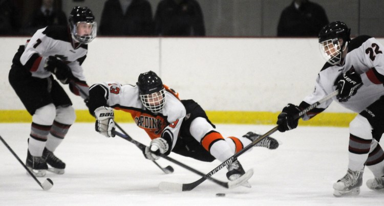 Gardiner Area High School’s Tristan Hebert, center, stick handles between Maranacook-Winthrop’s Bailey Clark, left, and Bailey Stockford during a Western B hockey game Wednesday afternoon at Kents Hill.