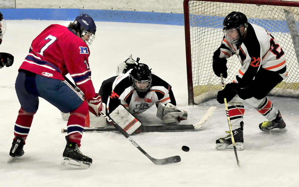 Winslow goalie Andrew Beals covers the net as Messalonskee forward Jake Dexter prepares to shoot during an eastern B game Wednesday night at Sukee Arena. At right, Winslow’s Dameron Rodrigue looks to defend on the play.