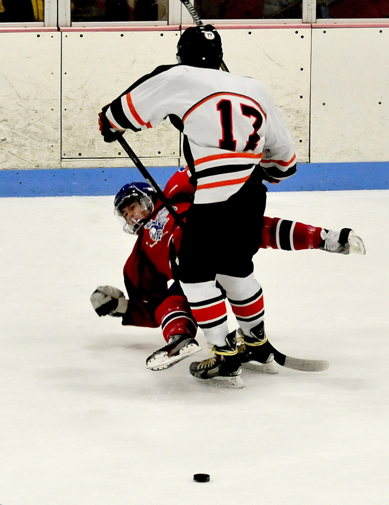 Winslow forward Alex Berard, front, slams into Messalonskee’s Dustin Brown during an Eastern B game Wednesday night at Sukee Arena.