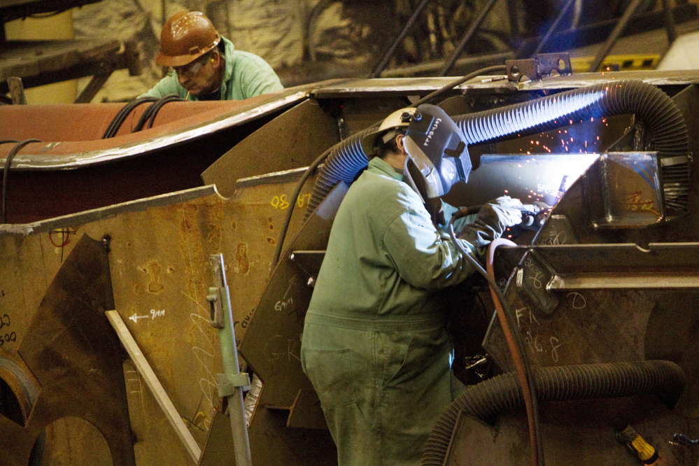 Shipbuilders work on the assembly of ship interior components at Bath Iron Works in Bath on Wednesday