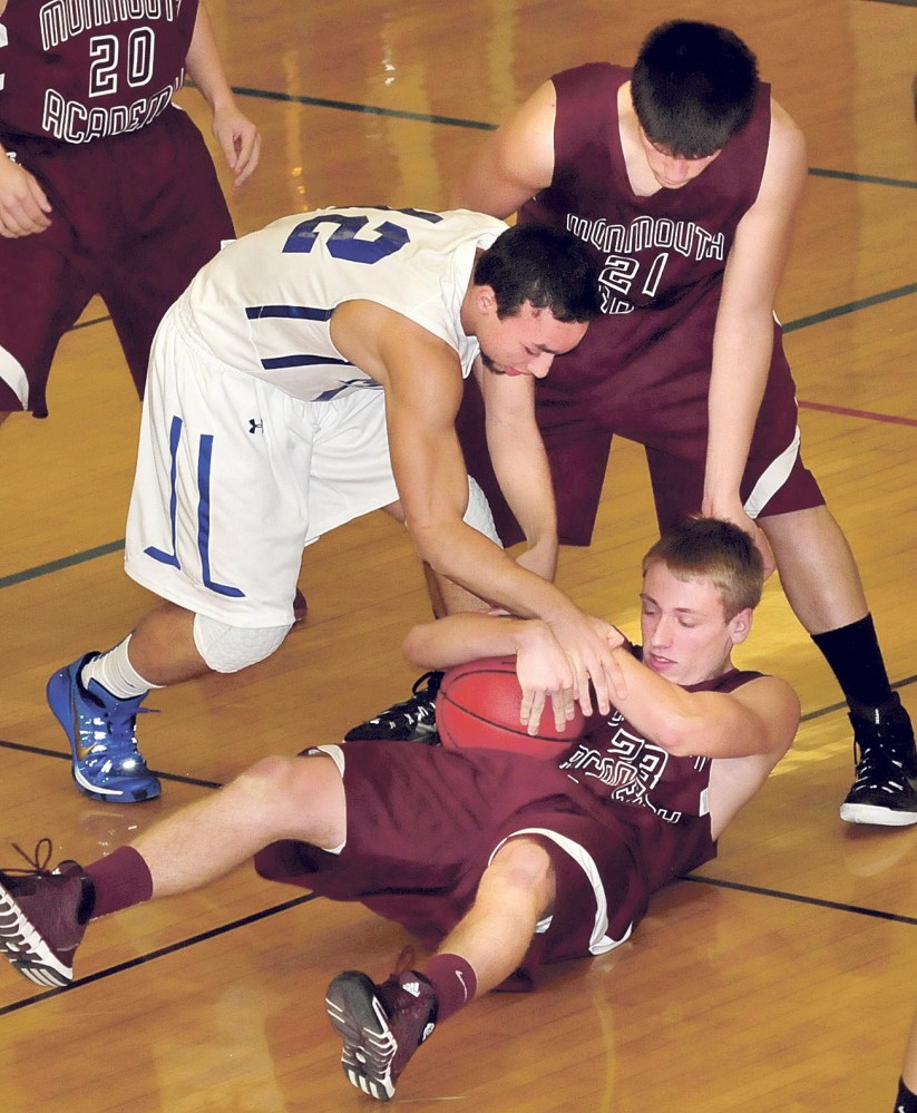 Monmouth’s Hunter Richardson (23) holds onto ball as Madison’s Nicholas Morales attempts to gain control during game Monday in Madison. Monmouth’s Kasey Smith is at right.