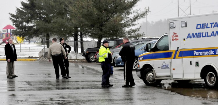 Police and school administrators including SAD 49 Superintendent Dean Baker, left, congregate in a parking lot beside an ambulance at Benton Elementary School in Benton on Wednesday afternoon. The school was placed in a lockdown after a man was seen cutting himself, a first responder said.