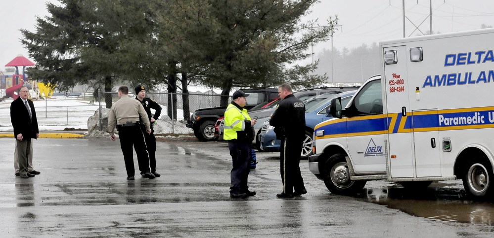 Police and school administrators, including School Administrative District 49 Superintendent Dean Baker, left, congregate in a parking lot Wednesday afternoon beside an ambulance at Benton Elementary School in Benton.