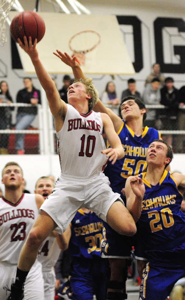 Hall-Dale’s Nat Crocker puts up a shot in front of Boothbay defenders Abel Bryer (50) and Nick Kilgus during a Western C game Friday in the Penny Gym at Hall-Dale High School in Farmingdale.