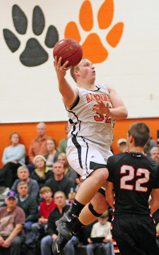 Gardiner’s Bradley Weston, left, goes up for a shot against Winslow’s Josh Kervin during a recent game. The Maine Principals’ Association is considering going from four classes to five classes beginning next year, a move that could have an impact on other sports and conferences.