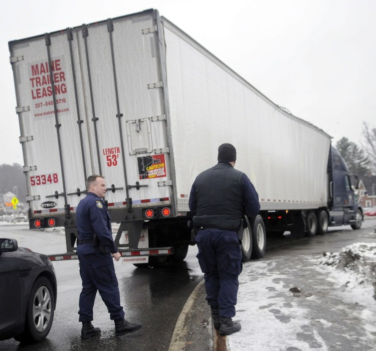 State Police Lt. Shawn Currie, left, confers with Trooper Patrick Munzing Tuesday after Currie pulled over a truck in Augusta that struck the train trestle on Water Street but failed to stop after the accident.