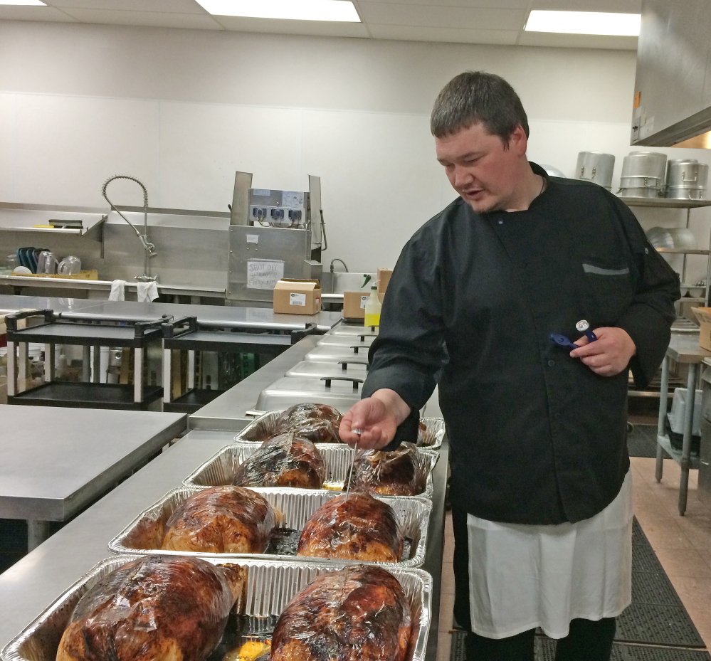 Staff photo by Rachel Ohm
Volunteer Rob Spence, of Clinton, prepares turkeys for the Central Maine Family Christmas Dinner on Tuesday. The turkeys are cooked ahead of time, while mashed potatoes, squash and other fixings are prepared by volunteers on Christmas morning.