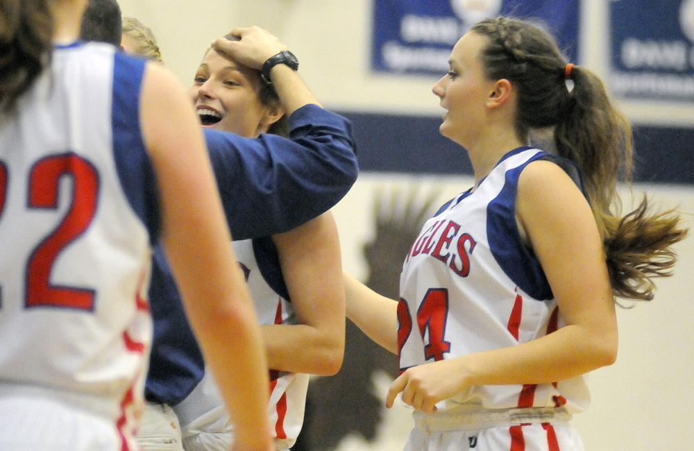 Messalonskee High School’s Sophia Holmes, center, gets a pat on the head by coach Keith Derobsy during a timeout against Bangor High School on Tuesday in Oakland.