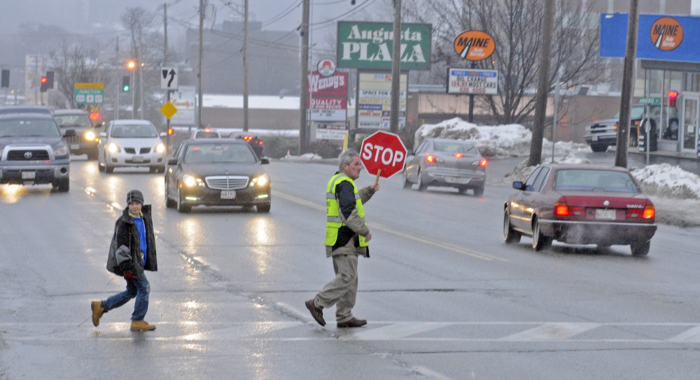Crossing guard Reggie Gagne has been hired by Augusta schools to help children cross busy Western Avenue following public outcry that a school board subcommittee voted to eliminate all crossing guards across the city.