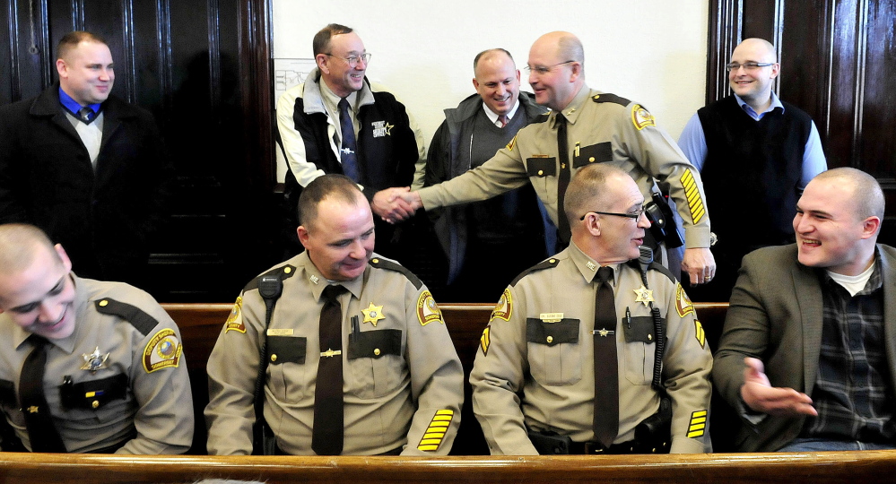 Dale Lancaster, right, shakes hands with retiring Penobscot County Sheriff Glenn Ross beside dozens of officers from several departments prior to a swearing-in ceremony as the new Somerset County Sheriff in Skowhegan on Monday.