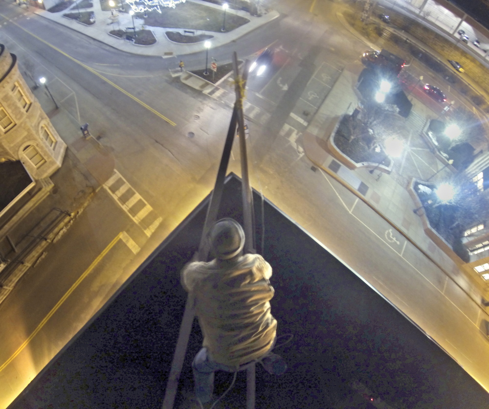 Working on the roof setting up the ropes, Jason McFarland prepares to raise the New Year’s Eve ball on Tuesday at Gagliano’s Bistro on Water Street in Augusta.