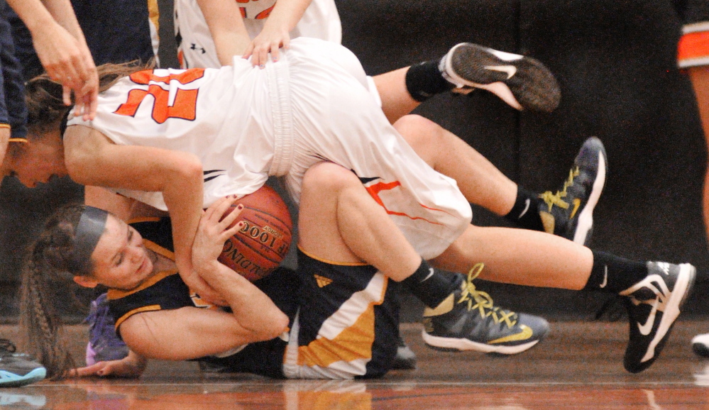 Gardiner’s Mary Toman, top and Medomak Valley’s Maggie Cox wrestle for a ball during a game Tuesday in the John A. Bragoli Memorial Gym at Gardiner Area High School.